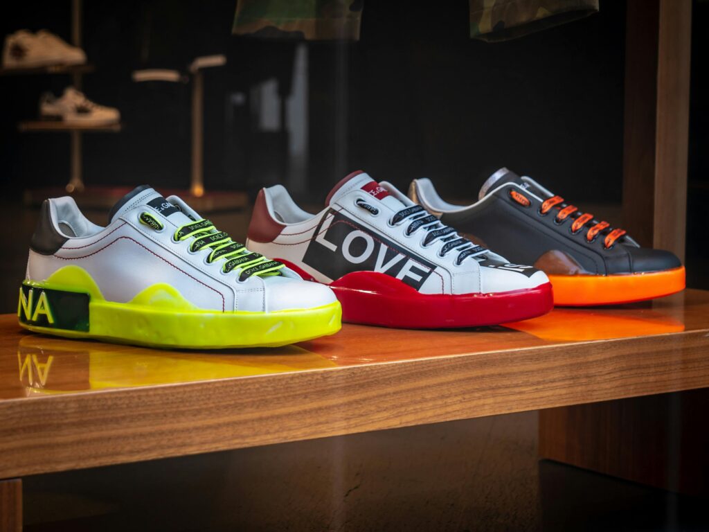 Vibrant colored sneakers displayed on a wooden table in a London store.